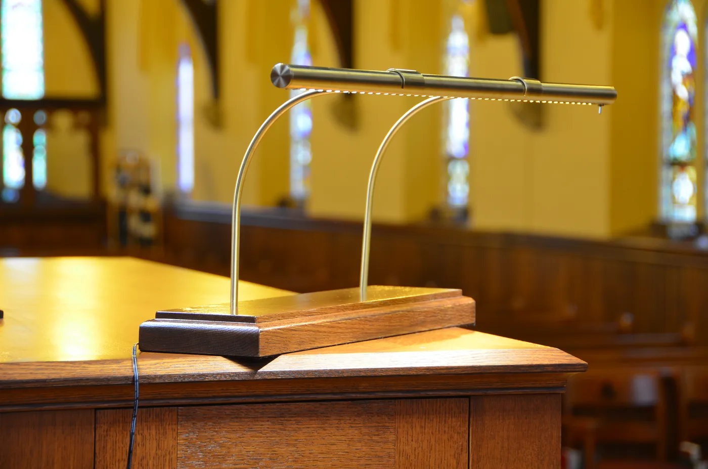 A finished brass organ music lamp on its solid hardwood base
